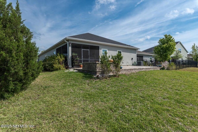 back of house with central AC unit, fence, a lawn, a sunroom, and a patio