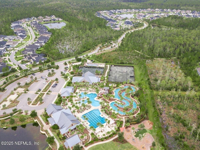 birds eye view of property with a wooded view and a water view