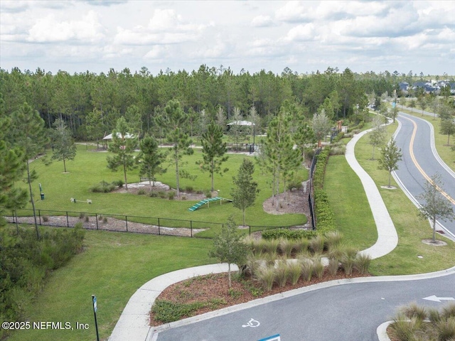 view of home's community with fence and a lawn