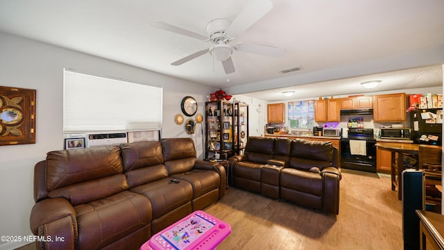living area featuring visible vents, light wood-style flooring, and ceiling fan