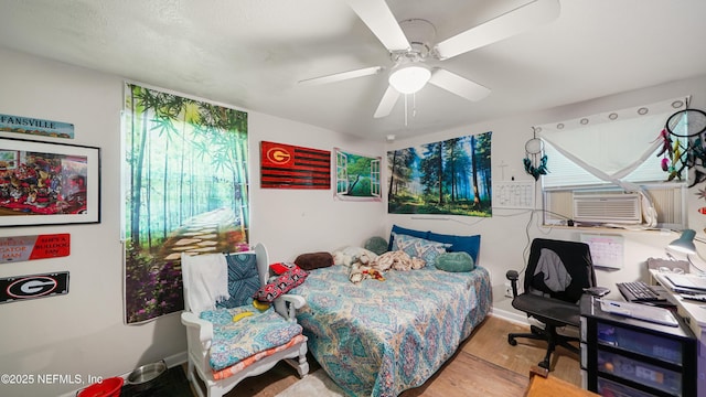 bedroom with cooling unit, a ceiling fan, and wood finished floors