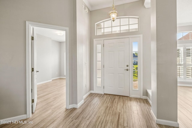 entryway with a wealth of natural light, wood finished floors, and baseboards