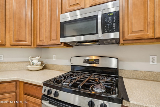 kitchen featuring light countertops, brown cabinets, and appliances with stainless steel finishes