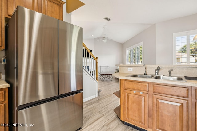 kitchen featuring visible vents, freestanding refrigerator, a sink, and a healthy amount of sunlight