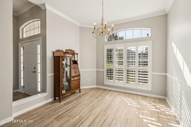 dining space with baseboards, a notable chandelier, wood finished floors, a high ceiling, and crown molding