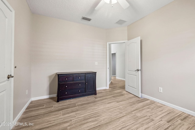 unfurnished bedroom featuring light wood-style flooring, visible vents, and a textured ceiling