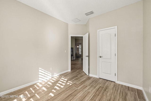 empty room with baseboards, visible vents, and light wood-style flooring