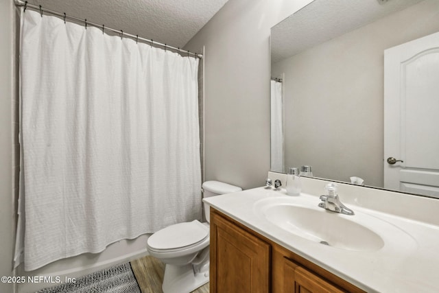 full bathroom featuring a textured ceiling, toilet, wood finished floors, shower / bathtub combination with curtain, and vanity