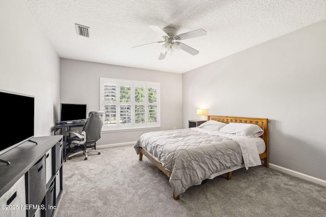 bedroom with a textured ceiling, baseboards, visible vents, carpet, and ceiling fan