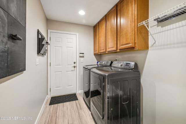 clothes washing area with washing machine and dryer, baseboards, recessed lighting, wood finished floors, and cabinet space