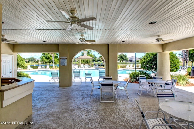 view of patio featuring a community pool and a ceiling fan