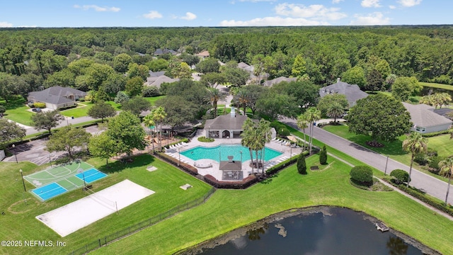 drone / aerial view featuring a forest view and a water view