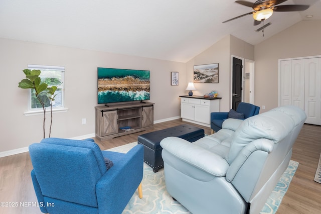 living room featuring vaulted ceiling, baseboards, ceiling fan, and light wood-style flooring