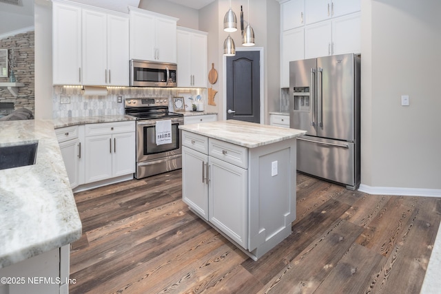 kitchen with dark wood-style floors, stainless steel appliances, light stone countertops, tasteful backsplash, and white cabinetry