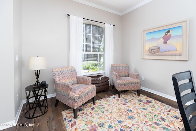 sitting room with baseboards, wood finished floors, and crown molding