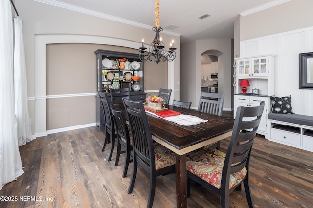 dining room with dark wood-style flooring, a chandelier, arched walkways, ornamental molding, and visible vents