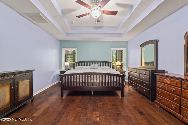 322 Cooper Bay Ct, Saint Augustine, FL 32092 - bedroom with visible vents, dark wood finished floors, a tray ceiling, and multiple windows