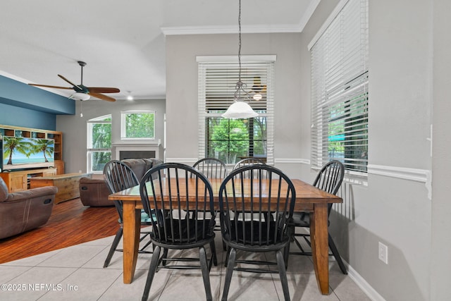 322 Cooper Bay Ct, Saint Augustine, FL 32092 - dining room featuring crown molding, a ceiling fan, light tile patterned floors, and a fireplace