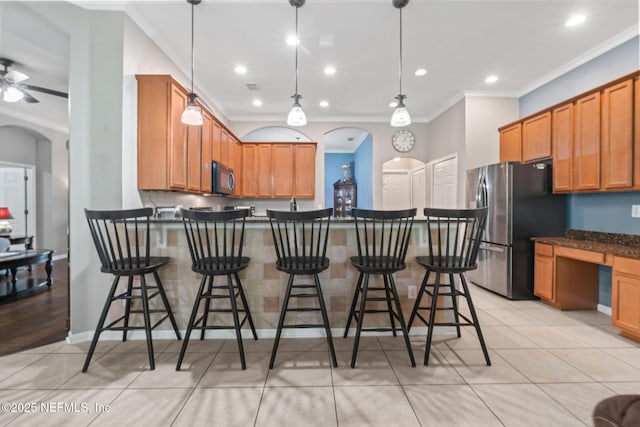 322 Cooper Bay Ct, Saint Augustine, FL 32092 - kitchen featuring crown molding, freestanding refrigerator, a breakfast bar, and a peninsula