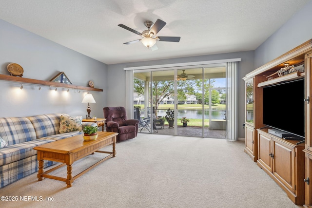 living room with ceiling fan, light carpet, and a textured ceiling