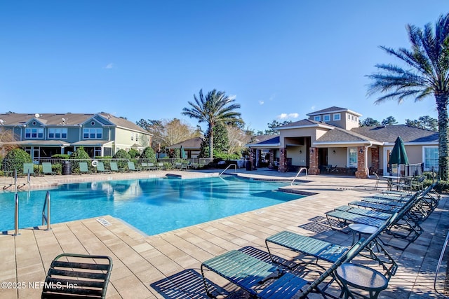 community pool featuring a patio and fence