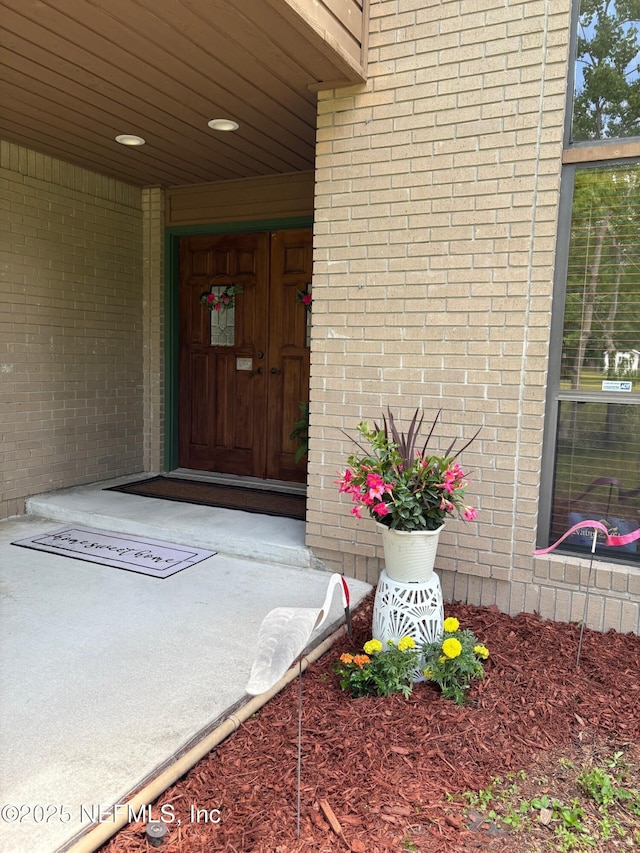 view of exterior entry with brick siding
