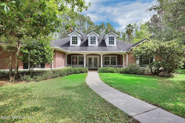 cape cod-style house with brick siding, a front lawn, french doors, and covered porch