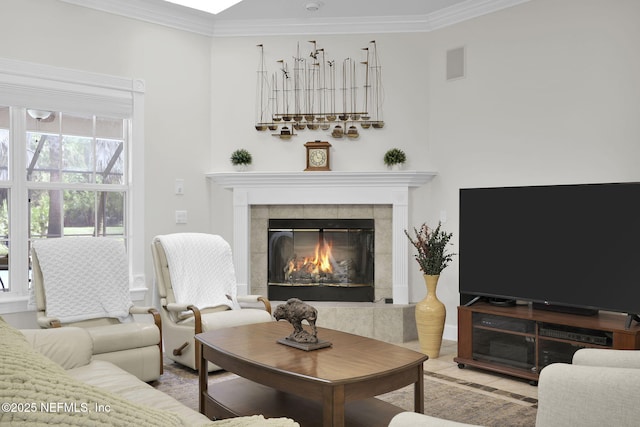 living room featuring ornamental molding, a tile fireplace, and visible vents