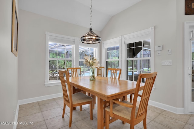 dining area with light tile patterned floors, baseboards, and vaulted ceiling