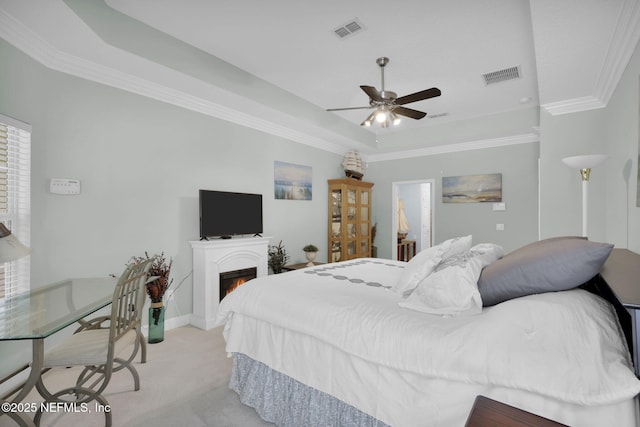 bedroom with visible vents, a raised ceiling, crown molding, and light carpet