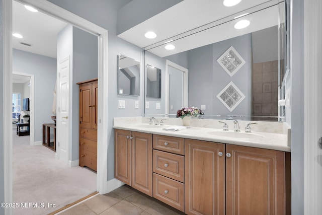 bathroom featuring double vanity, baseboards, visible vents, and a sink