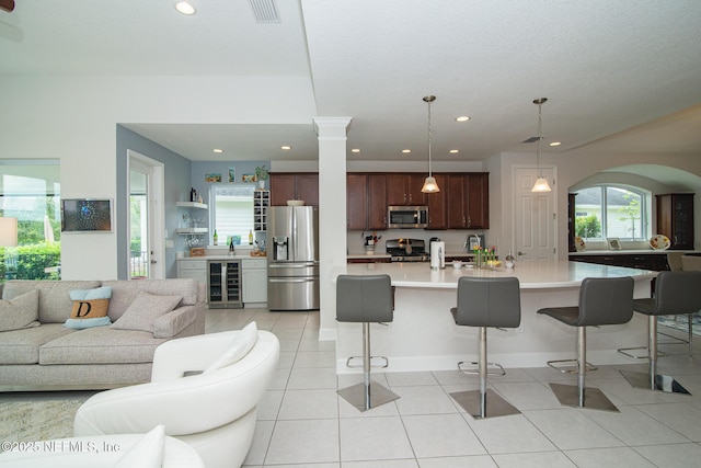 291 Whisper Rock Dr, Ponte Vedra, FL 32081 - living room featuring beverage cooler, light tile patterned floors, recessed lighting, and arched walkways