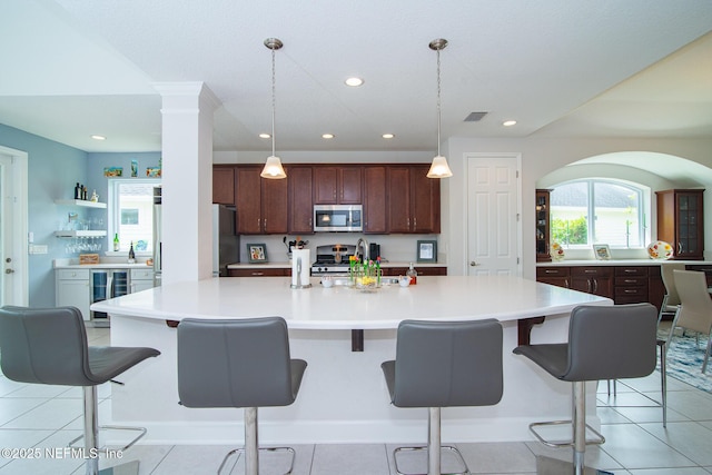 291 Whisper Rock Dr, Ponte Vedra, FL 32081 - kitchen featuring stainless steel appliances, wine cooler, light countertops, hanging light fixtures, and recessed lighting