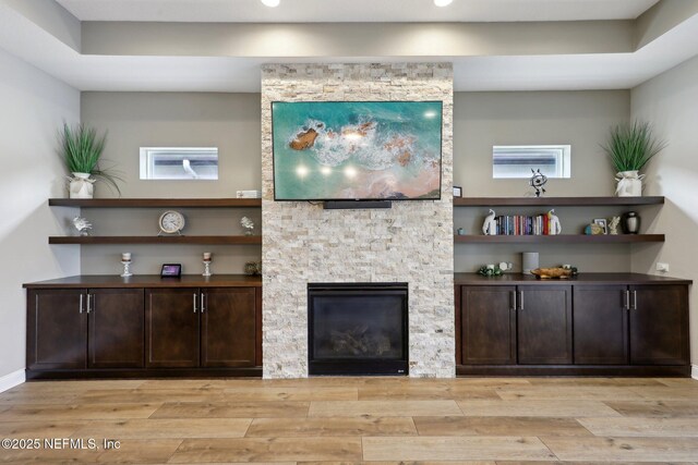 living room featuring a fireplace, wood finished floors, and recessed lighting
