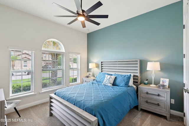 carpeted bedroom with lofted ceiling, baseboards, and multiple windows