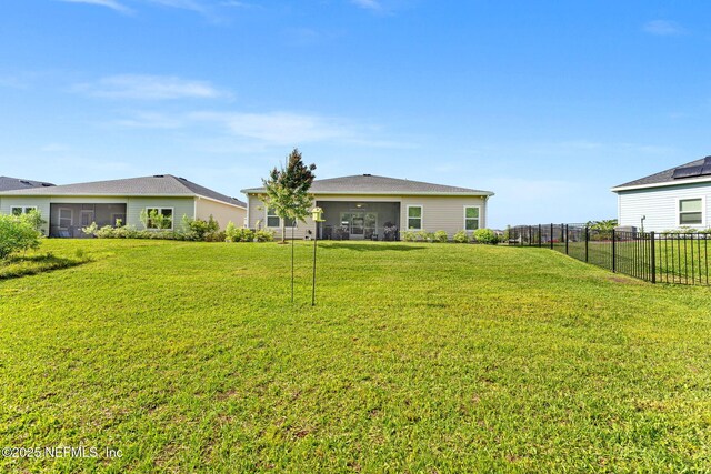 view of yard featuring a sunroom and fence