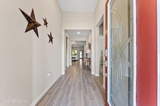 hallway featuring wood finished floors and baseboards