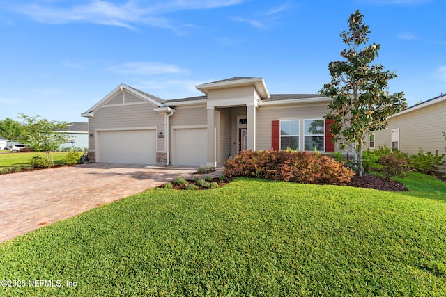 prairie-style home featuring a garage, a front lawn, stone siding, and decorative driveway