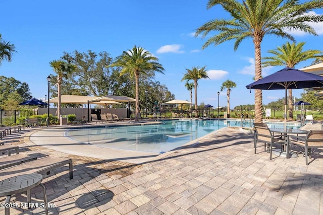 community pool featuring fence and a patio