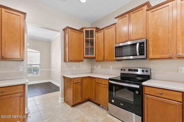 1124 Westfield Way, Saint Augustine, FL 32095 - kitchen featuring stainless steel appliances, glass insert cabinets, light tile patterned floors, baseboards, and light countertops