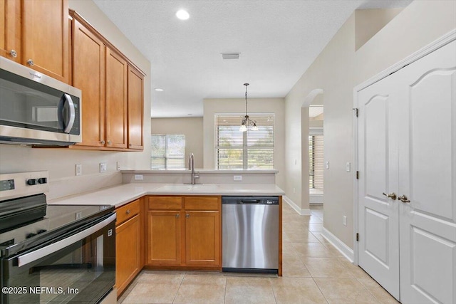 1124 Westfield Way, Saint Augustine, FL 32095 - kitchen with appliances with stainless steel finishes, a peninsula, brown cabinetry, and a sink