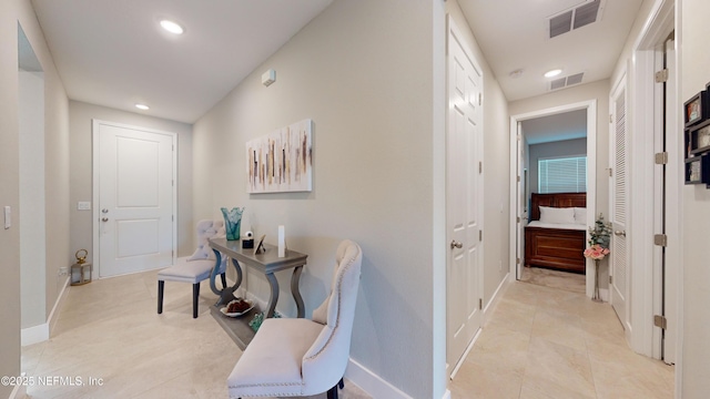 hallway with baseboards, visible vents, and recessed lighting