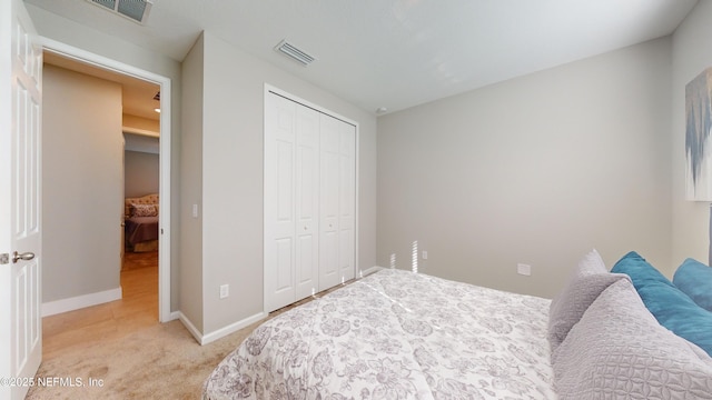 bedroom with light colored carpet, baseboards, visible vents, and a closet