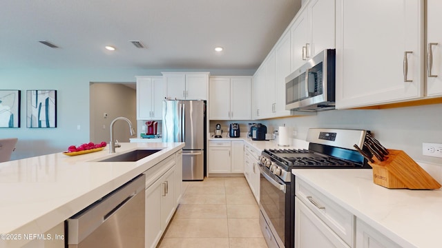 kitchen with light countertops, visible vents, a sink, appliances with stainless steel finishes, and white cabinetry