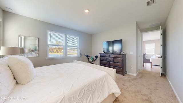 bedroom featuring baseboards, visible vents, and light colored carpet