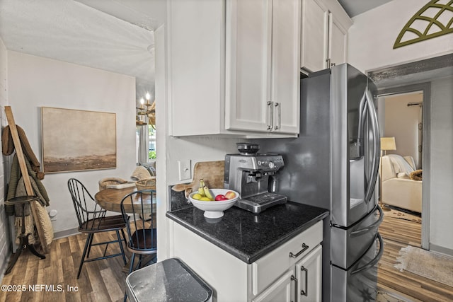 kitchen featuring dark wood-style floors, white cabinets, and dark stone counters