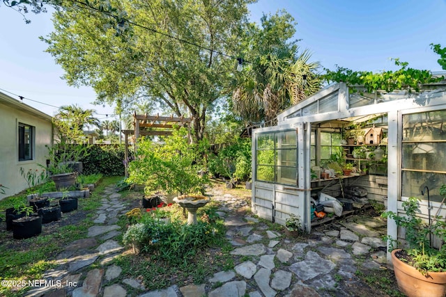 view of yard with an outbuilding, a vegetable garden, and a greenhouse