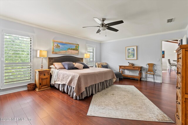 bedroom featuring dark wood-style floors, visible vents, a ceiling fan, and crown molding