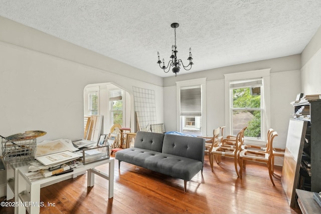 2234 Forbes St, Jacksonville, FL 32204 - living area featuring arched walkways, a textured ceiling, hardwood / wood-style flooring, and a notable chandelier