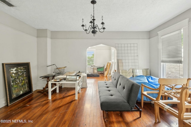 2234 Forbes St, Jacksonville, FL 32204 - dining space featuring a textured ceiling, hardwood / wood-style floors, arched walkways, a notable chandelier, and visible vents